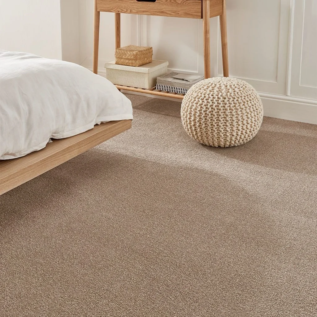 Beige bedroom carpet fitted in a modern minimalist bedroom with light wood furniture in Dubai